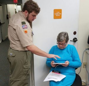 Eagle project leader, Jackson helping resident, Gail Jens